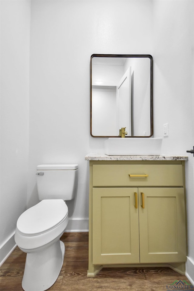 bathroom featuring vanity, hardwood / wood-style floors, and toilet