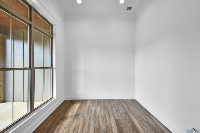 unfurnished room with hardwood / wood-style flooring and crown molding