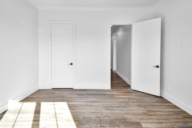 unfurnished bedroom with crown molding and wood-type flooring