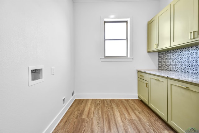 laundry area with hookup for a washing machine, cabinets, and light wood-type flooring