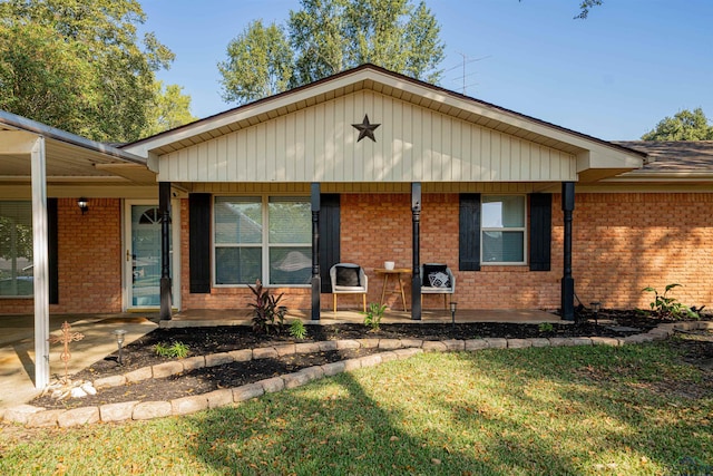 single story home featuring covered porch and a front yard