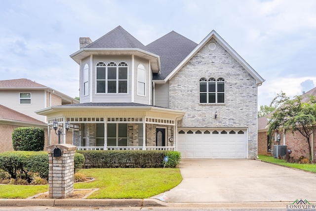 view of front of house with a front yard, a garage, and central air condition unit