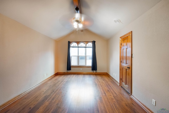 empty room with ceiling fan, wood-type flooring, and vaulted ceiling