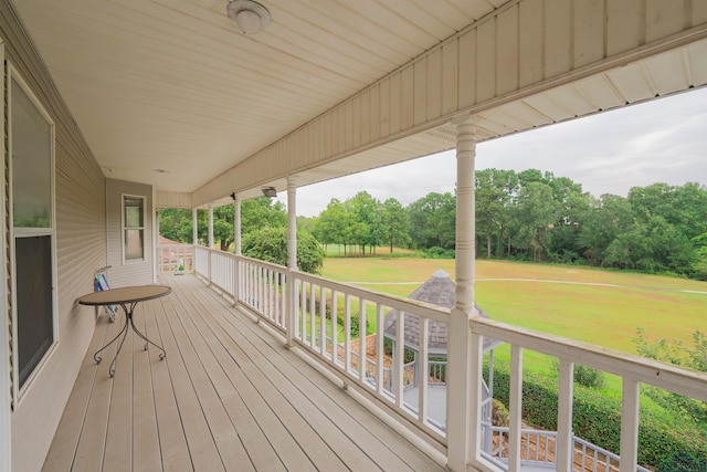 empty room featuring baseboards, vaulted ceiling, wood finished floors, and a ceiling fan