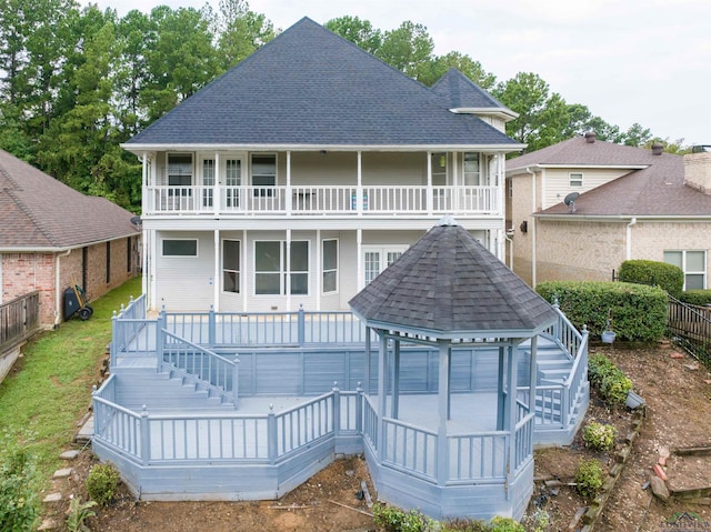 back of property with a gazebo and a balcony