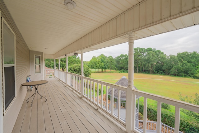 wooden deck featuring a yard and a porch