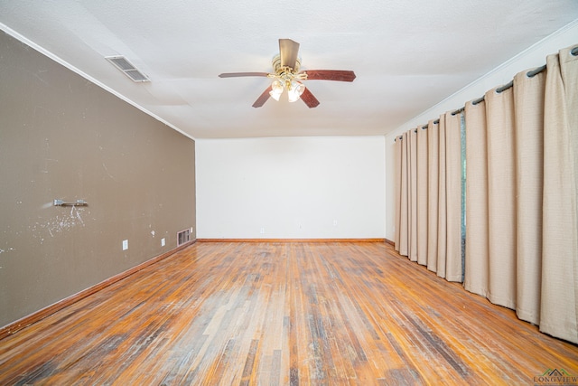 empty room featuring hardwood / wood-style floors, ceiling fan, and crown molding