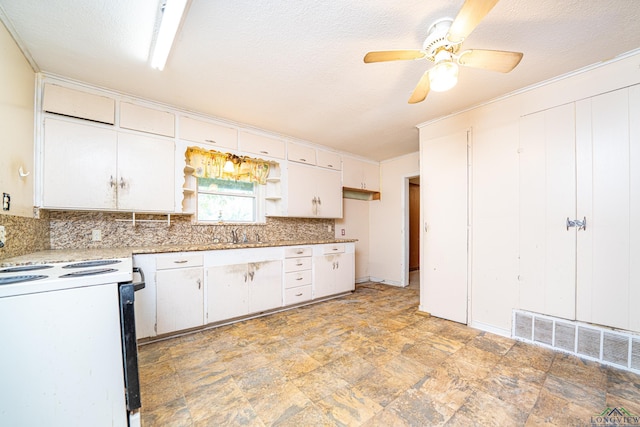 kitchen with range, a textured ceiling, white cabinetry, and ceiling fan