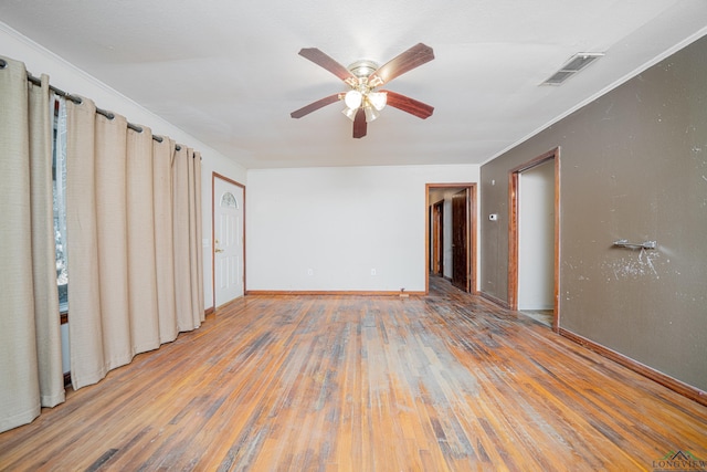 spare room with hardwood / wood-style floors, ceiling fan, and crown molding