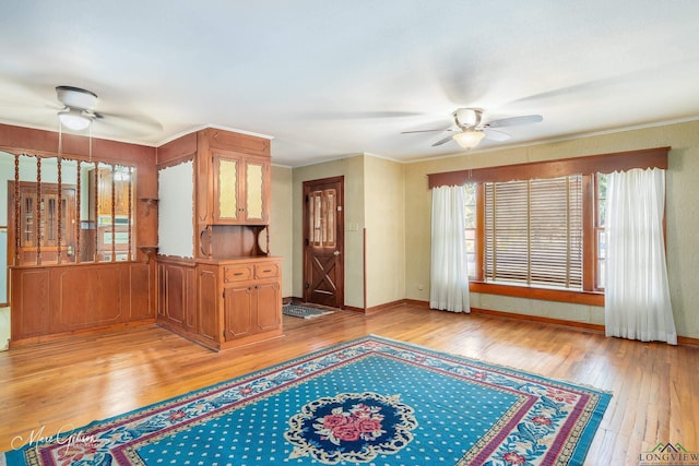 unfurnished living room with ceiling fan, ornamental molding, and light hardwood / wood-style floors