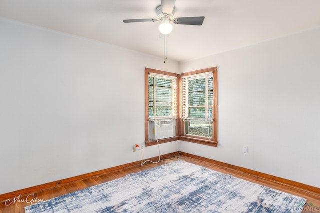 empty room featuring cooling unit, wood-type flooring, and ceiling fan