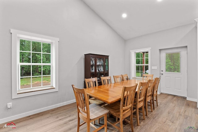 dining room with recessed lighting, light wood-style floors, baseboards, and high vaulted ceiling