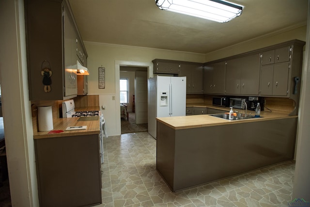 kitchen featuring crown molding, white appliances, kitchen peninsula, and sink