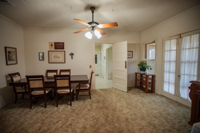 carpeted dining space with crown molding, french doors, ceiling fan, and a textured ceiling