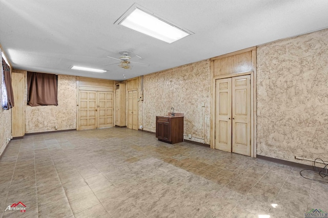 empty room featuring tile patterned floors, cooling unit, a textured ceiling, and a ceiling fan