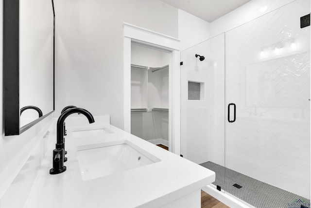 1513 Wellington Ln, Longview, TX 75605 - bathroom featuring a stall shower, a walk in closet, and double vanity