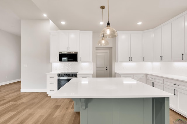 1513 Wellington Ln, Longview, TX 75605 - kitchen with appliances with stainless steel finishes, a center island, light countertops, tasteful backsplash, and white cabinetry