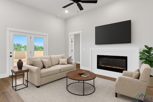 1513 Wellington Ln, Longview, TX 75605 - living area featuring wood finished floors, a ceiling fan, a glass covered fireplace, baseboards, and a towering ceiling
