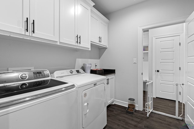 laundry room featuring cabinets, dark wood-type flooring, and washing machine and clothes dryer