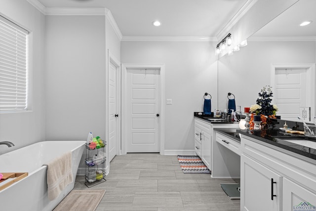 bathroom with a bathing tub, vanity, and crown molding