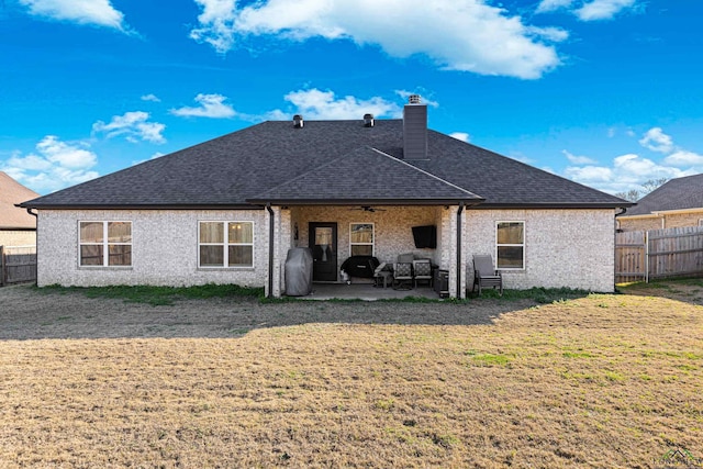 rear view of property with a patio area, ceiling fan, and a yard