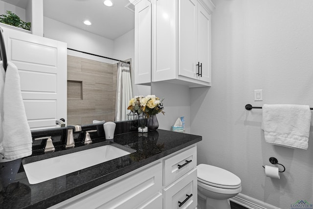 bathroom featuring vanity, toilet, and walk in shower