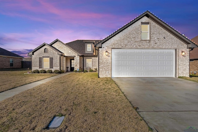 front facade featuring a yard and a garage