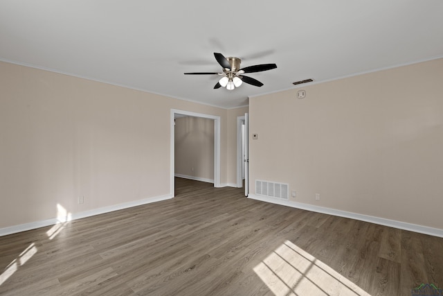 empty room with hardwood / wood-style floors, ceiling fan, and ornamental molding