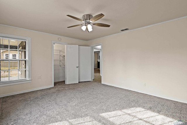 unfurnished bedroom with a closet, carpet floors, ceiling fan, and ornamental molding