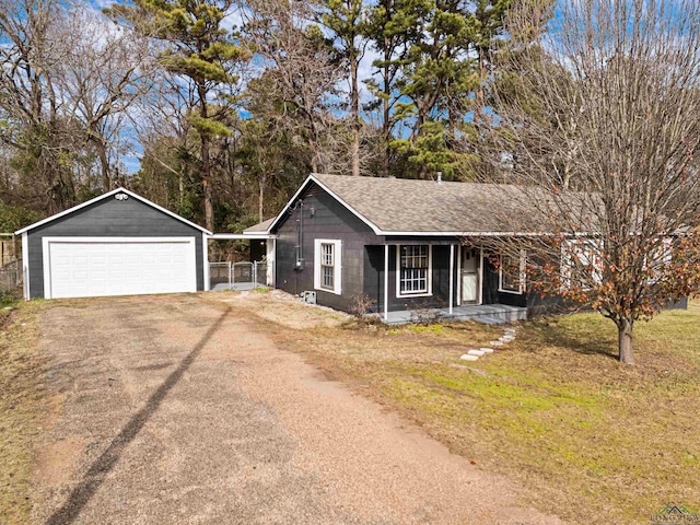 ranch-style house with a front yard, covered porch, an outbuilding, and a garage