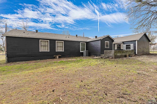 rear view of property featuring cooling unit and a lawn