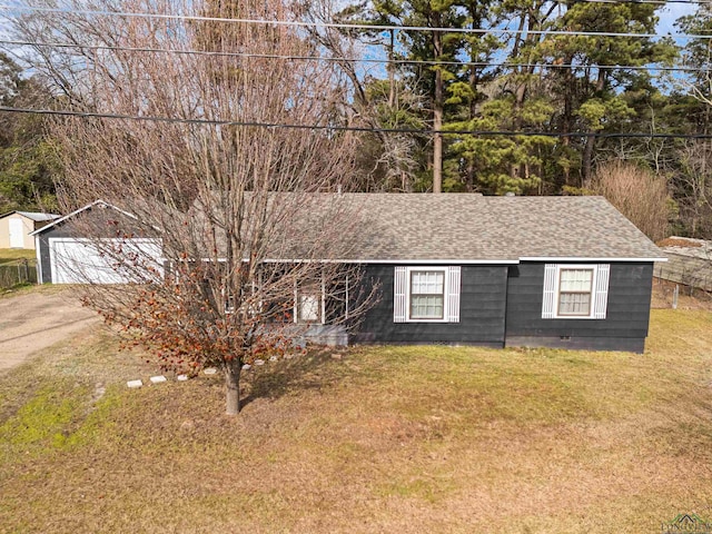 ranch-style house with a front yard, a garage, and an outbuilding