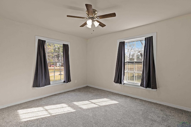 spare room with ceiling fan, carpet flooring, and plenty of natural light