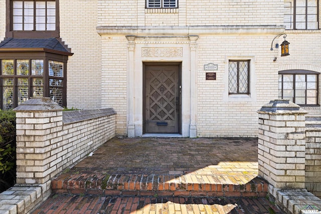 view of exterior entry featuring brick siding