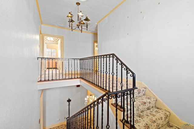 stairs featuring a chandelier, ornamental molding, and baseboards