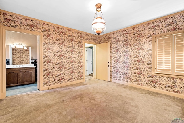 carpeted spare room with wallpapered walls and baseboards