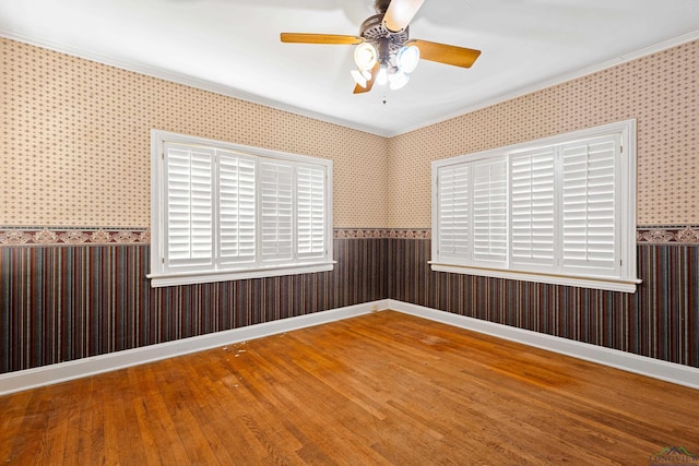 empty room with baseboards, wood finished floors, and wallpapered walls