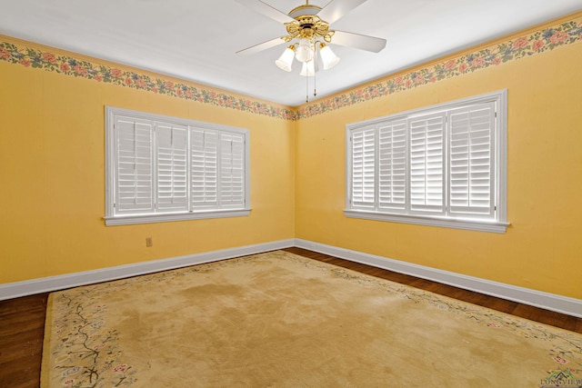 spare room with baseboards, a ceiling fan, and wood finished floors