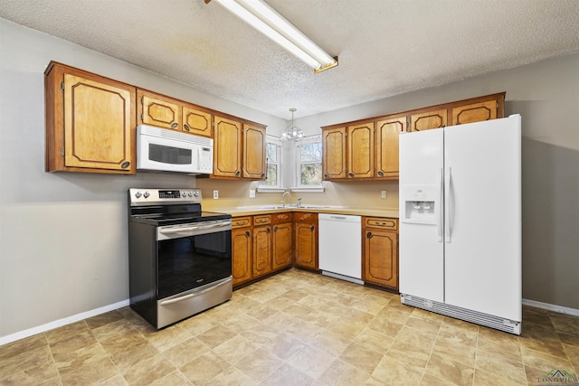 1324 Annette Dr, Longview, TX 75604 - kitchen featuring white appliances, brown cabinets, light countertops, and a textured ceiling