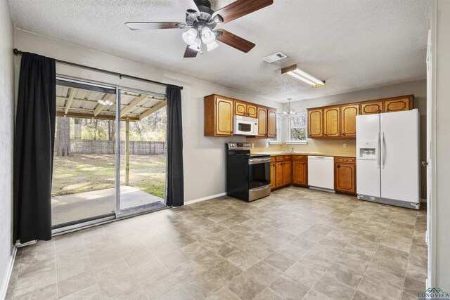 1324 Annette Dr, Longview, TX 75604 - kitchen featuring white appliances, a textured ceiling, ceiling fan, light countertops, and brown cabinetry