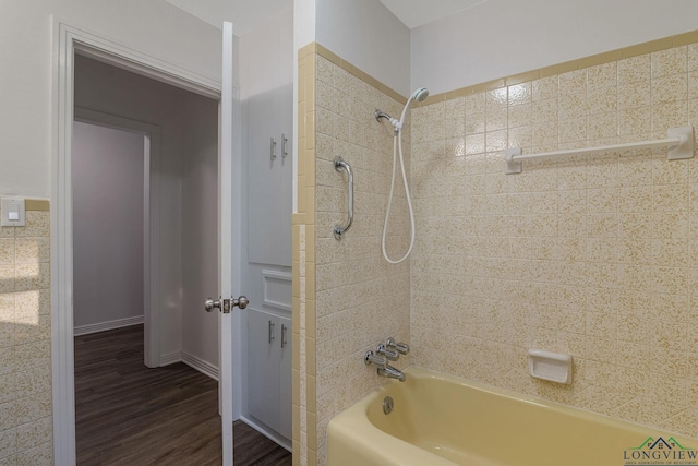 bathroom with hardwood / wood-style floors and tiled shower / bath combo