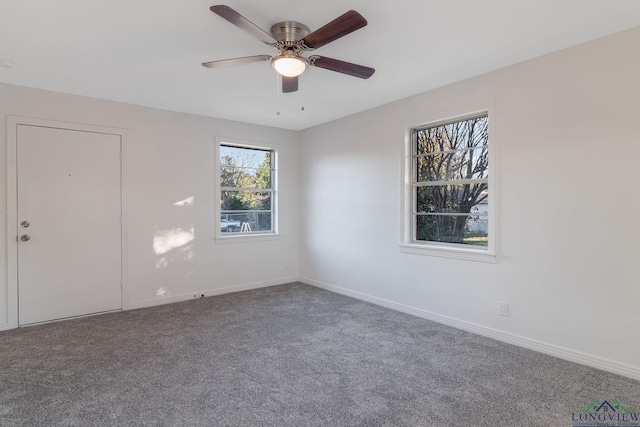 carpeted spare room featuring ceiling fan