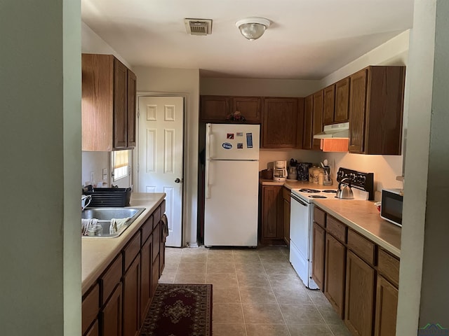 719 N Court St, Longview, TX 75601 - kitchen featuring sink, light tile patterned floors, and white appliances
