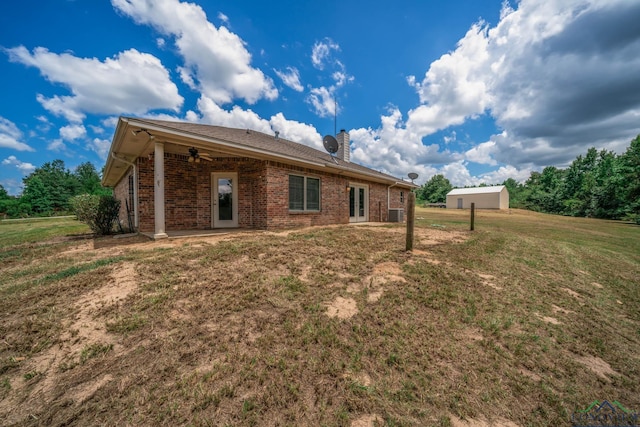 16591 Landons Way, Winona, TX 75792 - rear view of house with ceiling fan, a lawn, brick siding, a chimney, and a patio