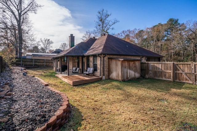 rear view of house featuring a yard and a wooden deck