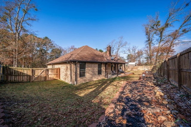 rear view of property featuring a lawn and a patio