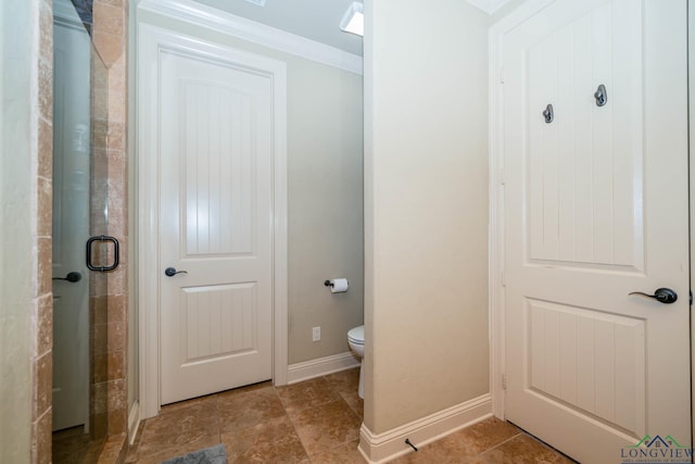 bathroom featuring crown molding, a shower with door, and toilet