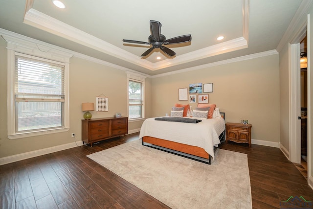 bedroom featuring dark wood-type flooring, a tray ceiling, ceiling fan, and crown molding