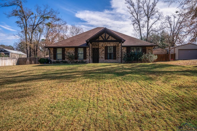 view of front of property featuring a garage, an outdoor structure, and a front lawn