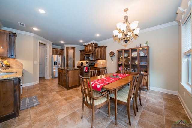 dining area featuring an inviting chandelier, crown molding, and sink